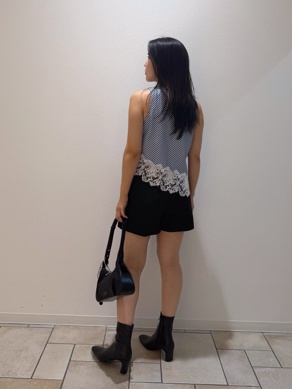 ブラック系のその他パンツ、ブラック系のブーツ、ブルー系のシャツ/ブラウスを着用したレディースの秋コーディネートの3枚目の写真