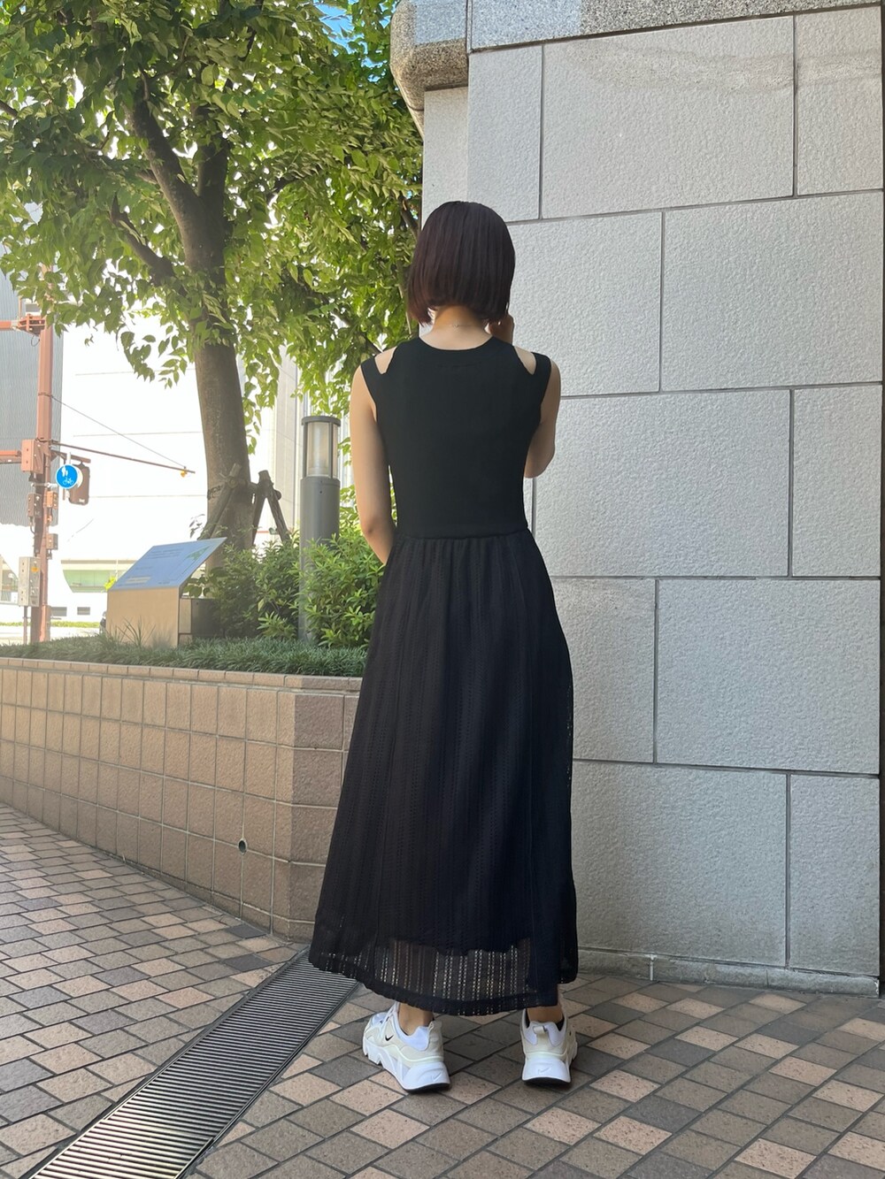 ブラック系のワンピース、パープル系のハンドバッグを着用したレディースの夏コーディネートの4枚目の写真