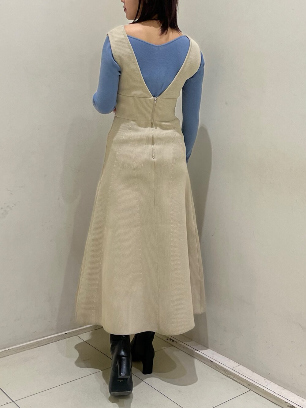 ブラック系のブーツ、ホワイト系のジャンパースカート、ブルー系のニット/セーターを着用したレディースの冬コーディネートの3枚目の写真