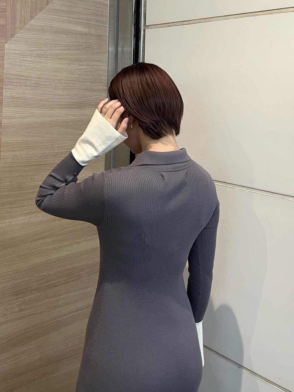 グレー系のワンピース、ホワイト系のスニーカー、シルバー系のショルダーバッグを着用したレディースの冬コーディネートの6枚目の写真