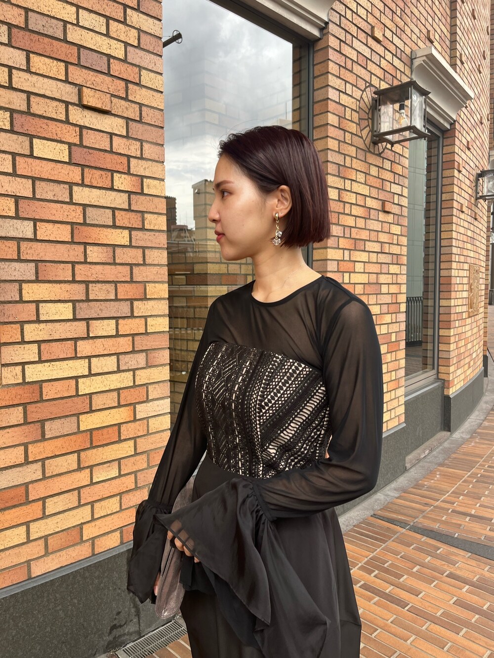 ブラック系のTシャツ/カットソー、ブラック系のドレス、シルバー系のハンドバッグを着用したレディースの秋コーディネートの3枚目の写真