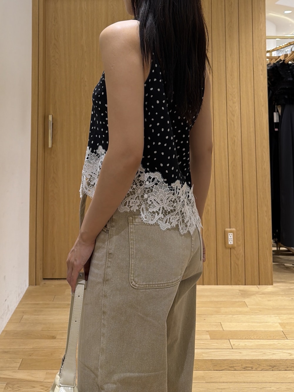 ブラック系のブーツ、ホワイト系のハンドバッグ、ブラック系のシャツ/ブラウスを着用したレディースの秋コーディネートの6枚目の写真