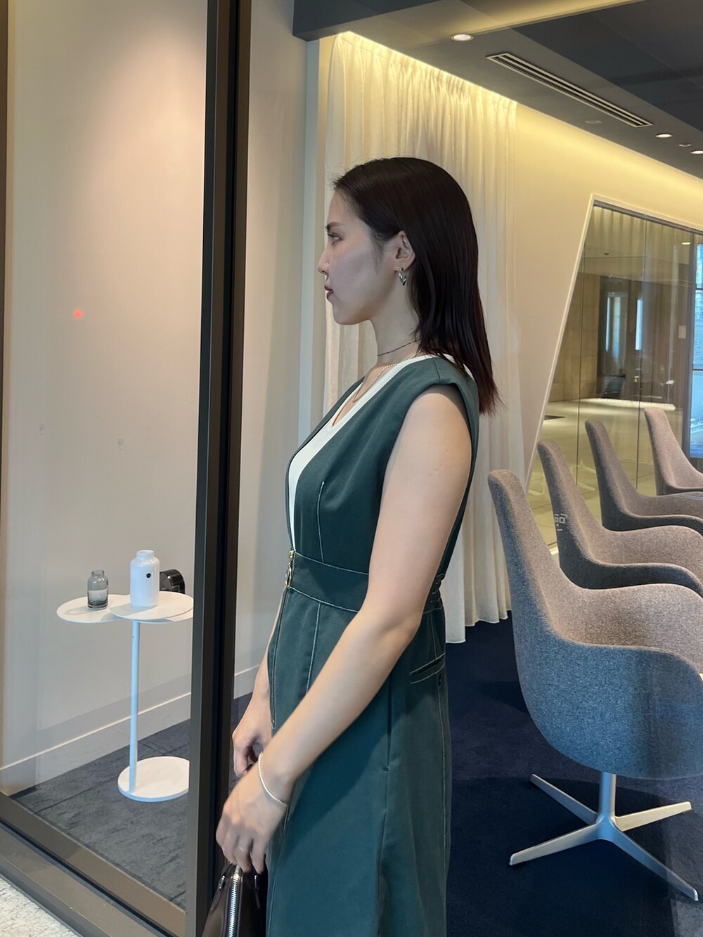 ブラウン系のパンプス、ブラウン系のボストンバッグ、ホワイト系のTシャツ/カットソーを着用したレディースの夏コーディネートの5枚目の写真