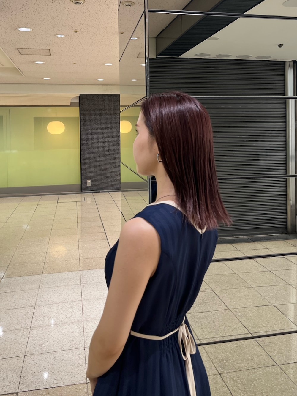 ブルー系のワンピース、ブラウン系のハンドバッグ、ブラック系のサンダルを着用したレディースの夏コーディネートの6枚目の写真