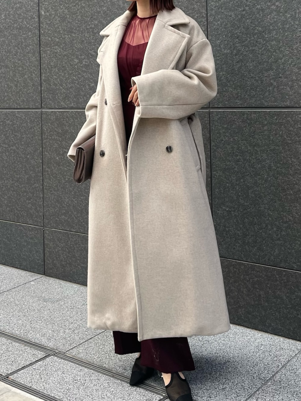 レッド系のパンツドレス、ホワイト系のチェスターコートを着用したレディースの冬コーディネートの4枚目の写真