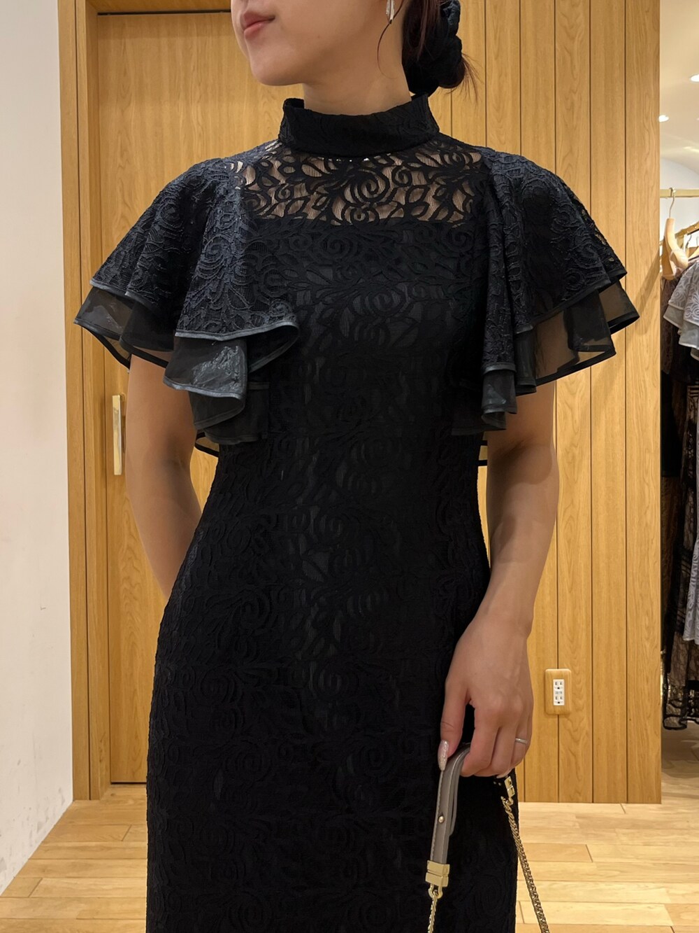 ブラック系のドレス、シルバー系のパンプス、シルバー系のクラッチバッグを着用したレディースの秋コーディネートの4枚目の写真