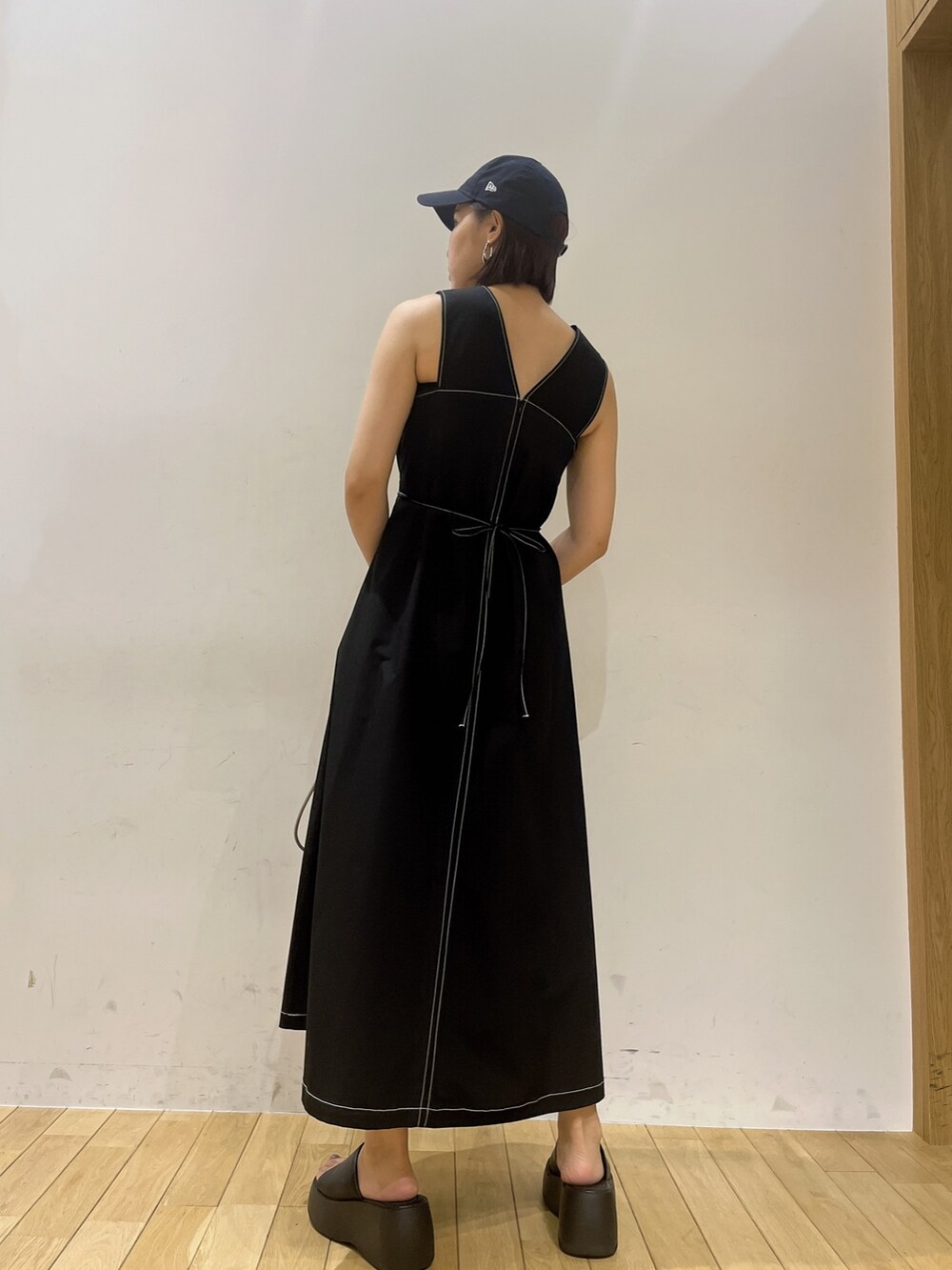 ベージュ系のハンドバッグ、ブラック系のワンピースを着用したレディースの夏コーディネートの3枚目の写真