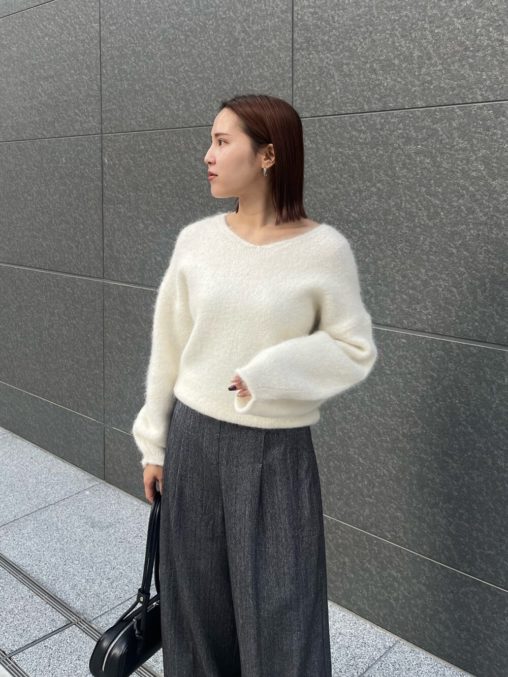 グレー系のその他パンツ、ホワイト系のニット/セーター、ブラック系のショルダーバッグを着用したレディースの冬コーディネートの4枚目の写真
