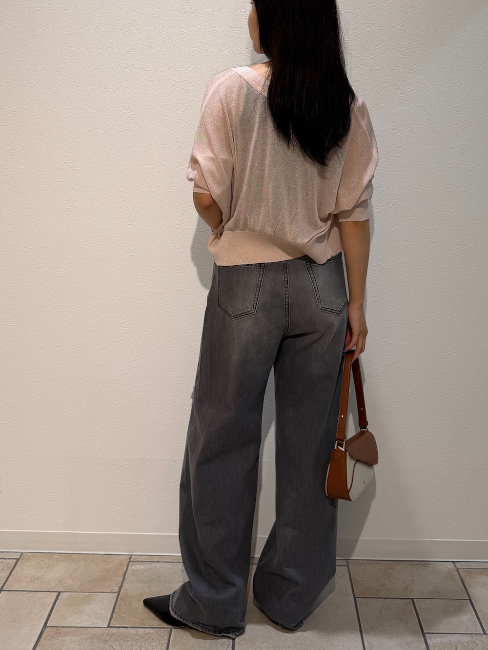 ブラック系のパンプス、ブラウン系のハンドバッグ、ブラック系のタンクトップを着用したレディースの夏コーディネートの3枚目の写真