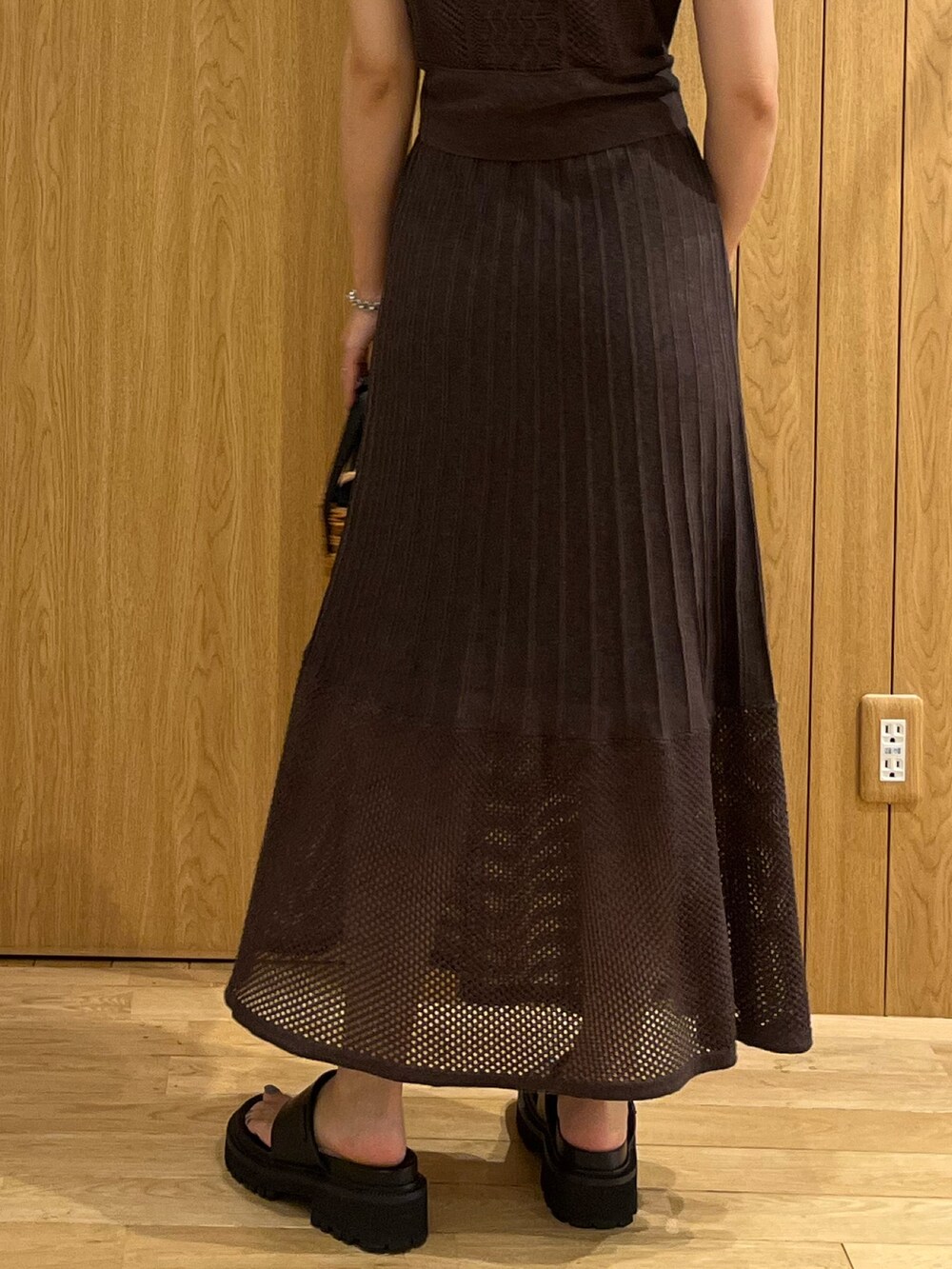 ブラウン系のハンドバッグ、ブラウン系のワンピース、シルバー系のネックレスを着用したレディースの夏コーディネートの4枚目の写真