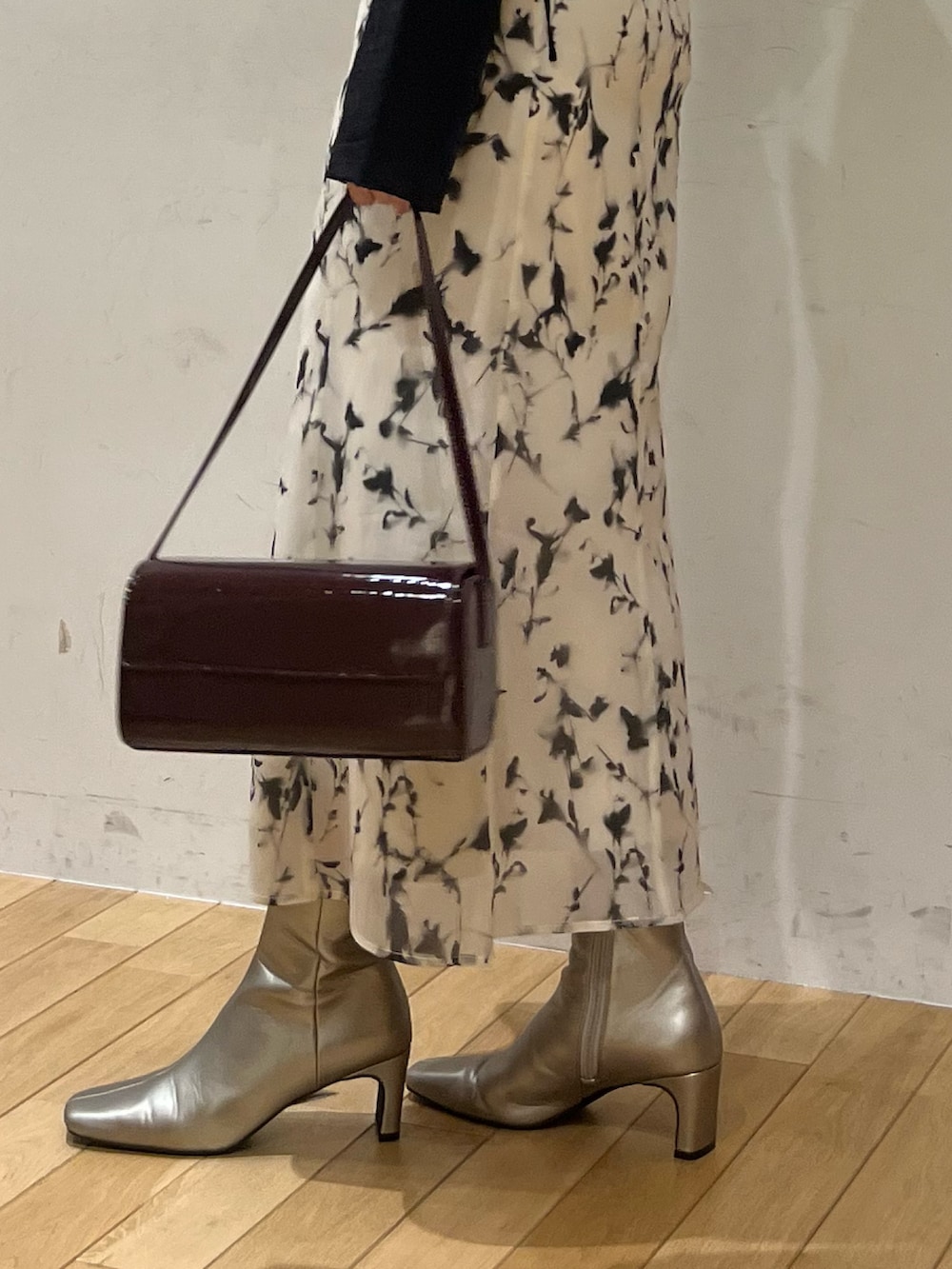 ホワイト系のスカート、レッド系のショルダーバッグ、ブラック系のシャツ/ブラウスを着用したレディースの秋コーディネートの7枚目の写真