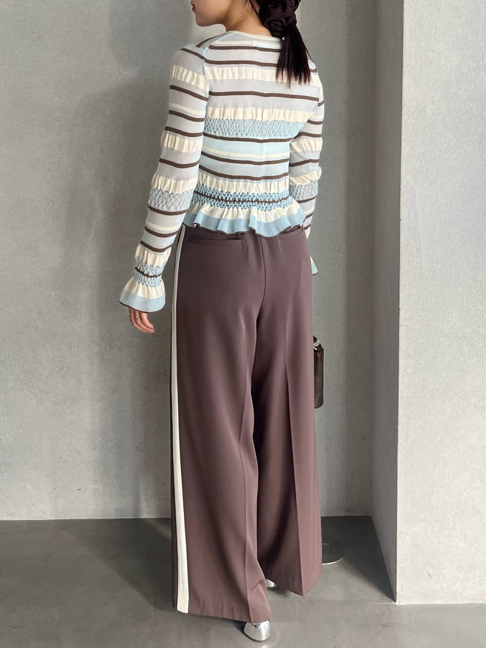 ブラウン系のハンドバッグ、ブラウン系のパンプス、ブラウン系のその他パンツを着用したレディースの冬コーディネートの3枚目の写真