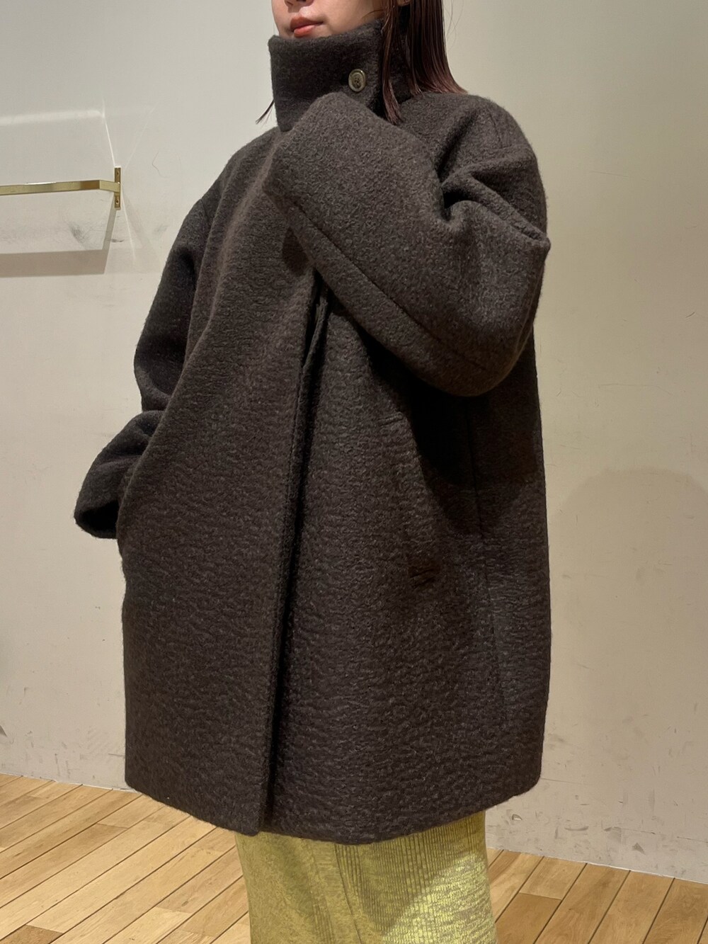 ブラウン系のその他アウター、グリーン系のワンピース、ブラック系のブーツを着用したレディースの冬コーディネートの6枚目の写真