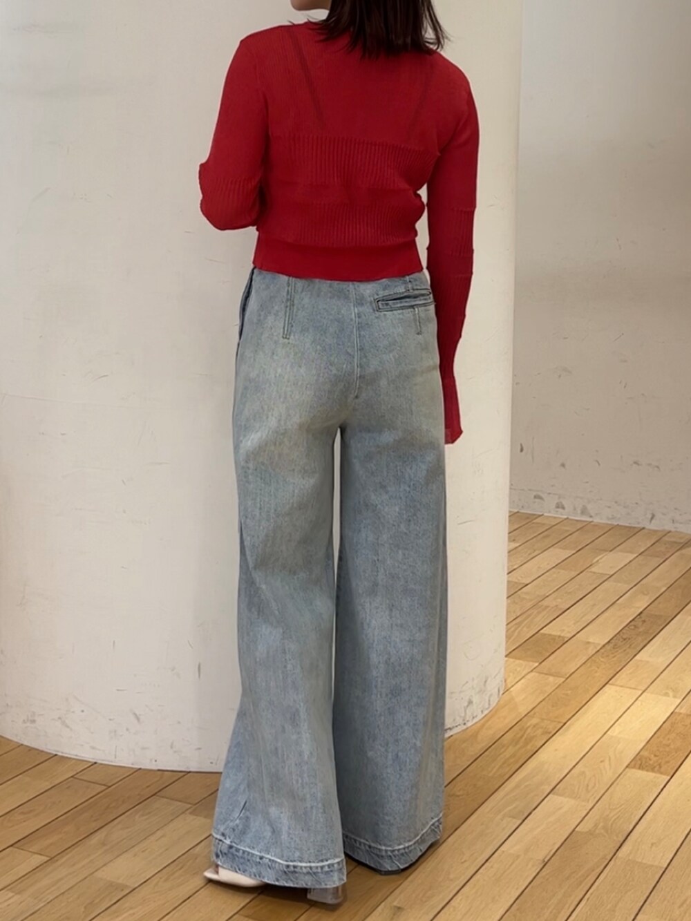 ブルー系のデニムパンツ、レッド系のカーディガン/ボレロ、ホワイト系のサンダルを着用したレディースの春コーディネートの3枚目の写真