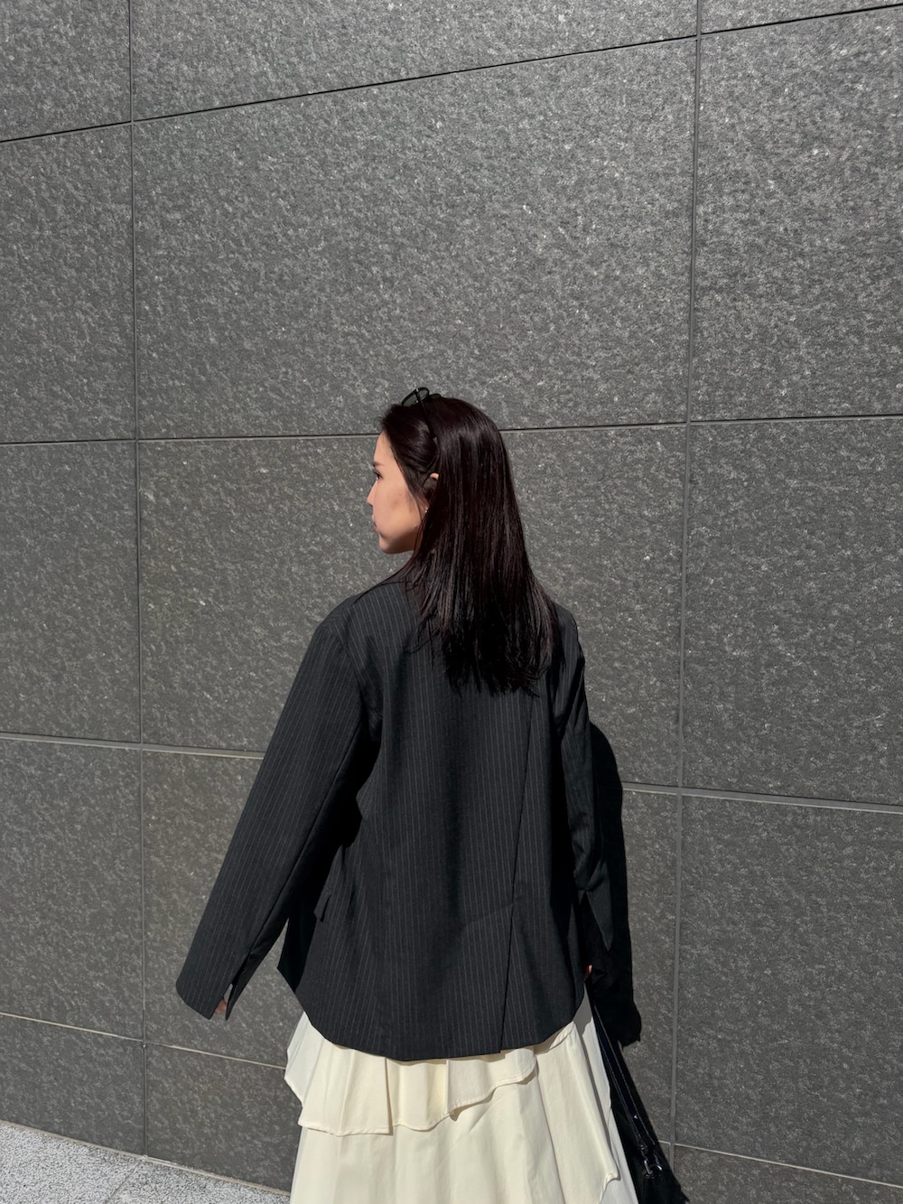 ホワイト系のスカート、ブラック系のニット/セーター、ブラック系のハンドバッグを着用したレディースの冬コーディネートの5枚目の写真