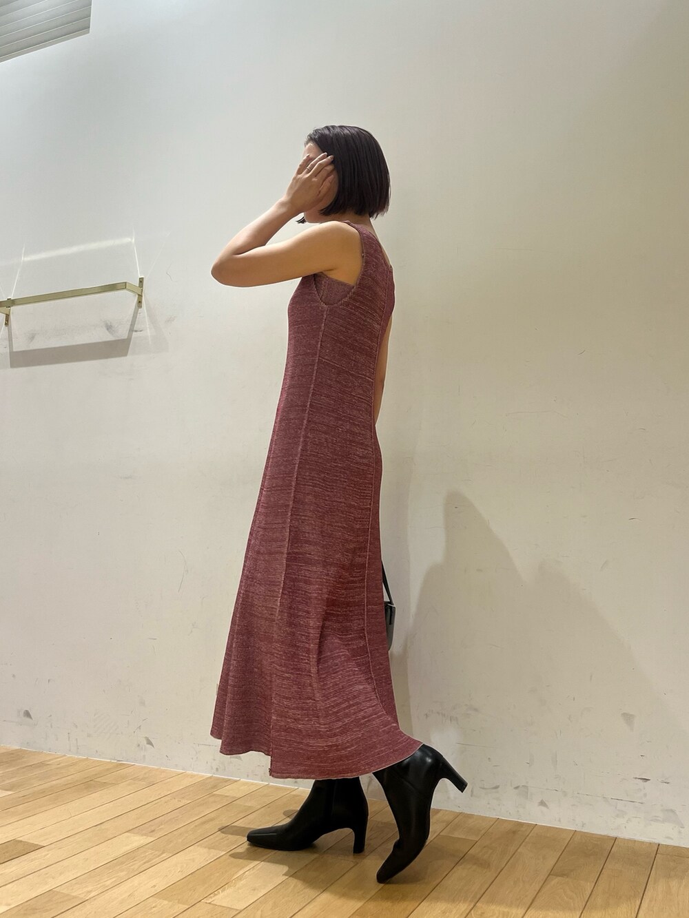 パープル系のワンピース、ブラック系のショルダーバッグ、ブラック系のブーツを着用したレディースの夏コーディネートの2枚目の写真