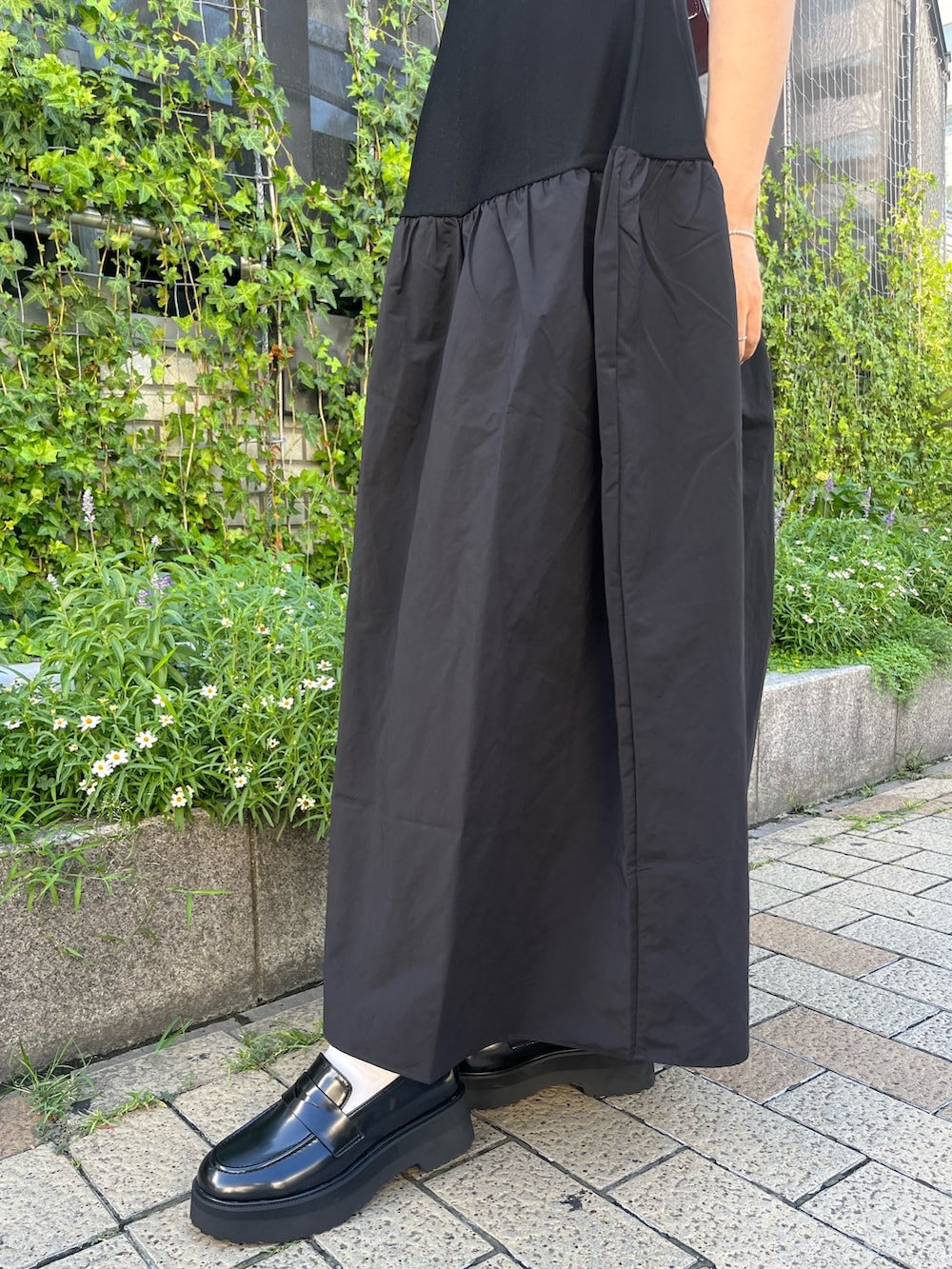 レッド系のショルダーバッグ、ブラック系のワンピース、ブラック系のローファーを着用したレディースの秋コーディネートの6枚目の写真