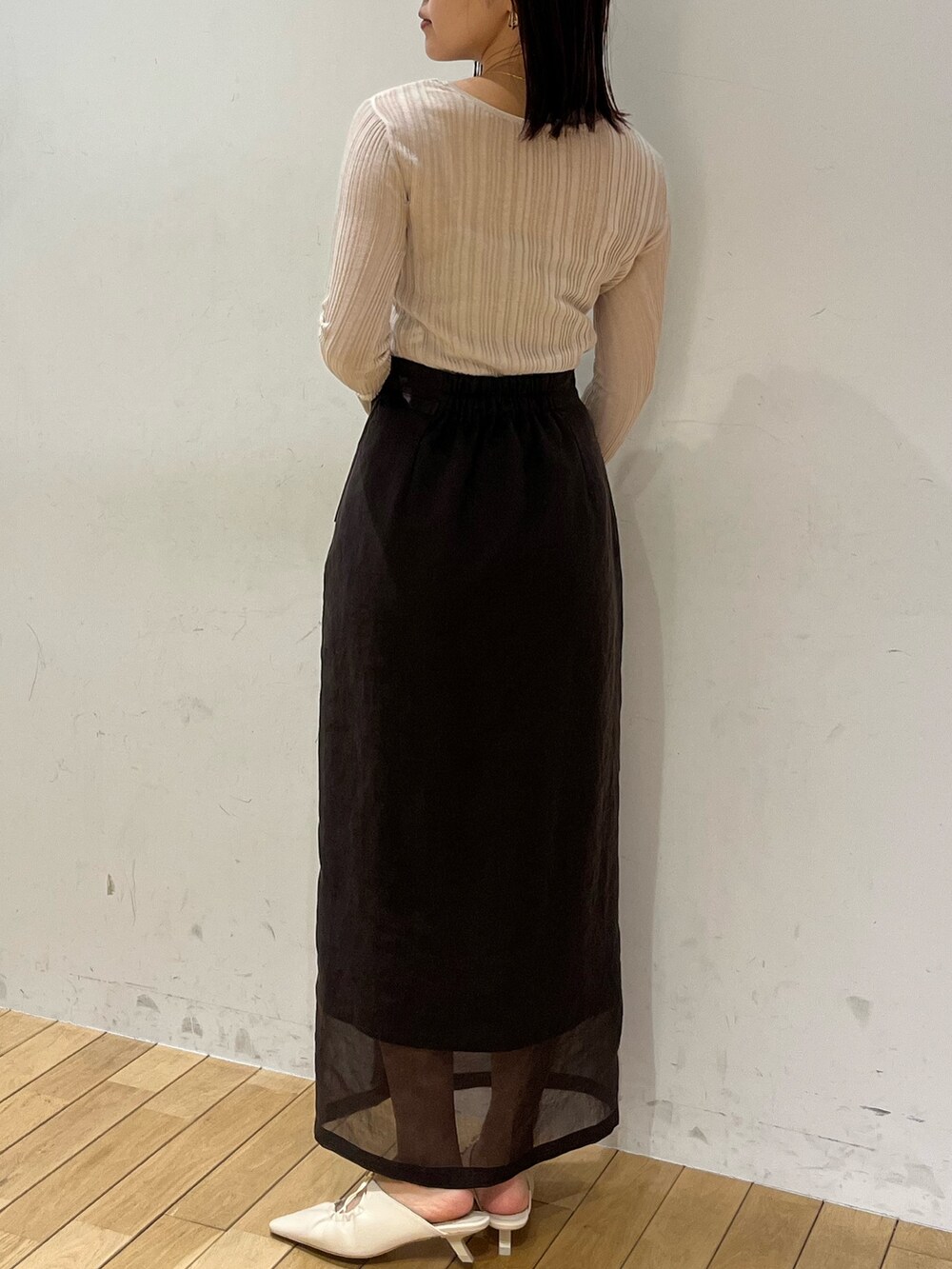 ブラウン系のスカート、ホワイト系のTシャツ/カットソー、ホワイト系のサンダルを着用したレディースの春コーディネートの3枚目の写真