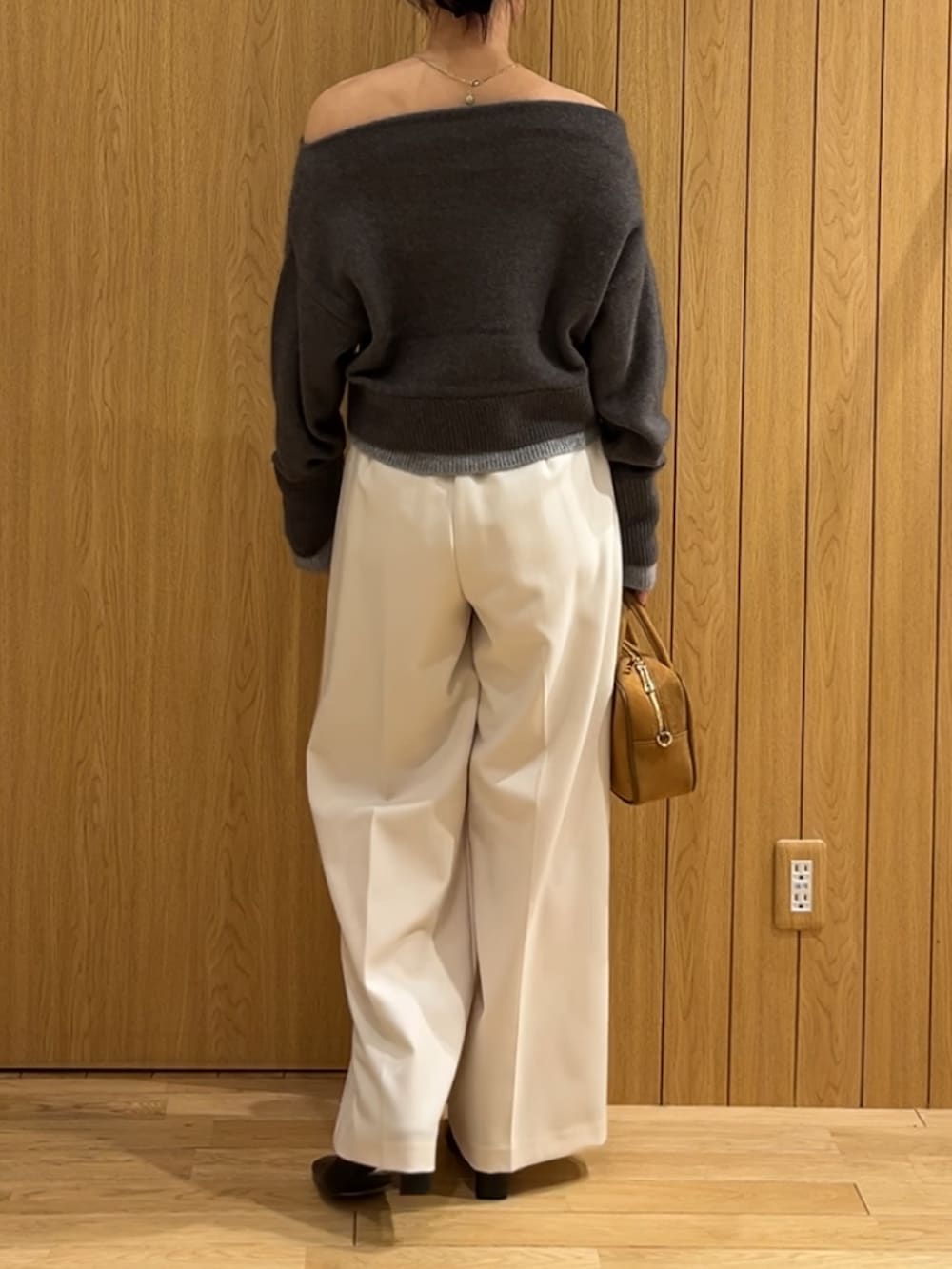 ホワイト系のその他パンツ、ブラック系のブーツ、ブラウン系のハンドバッグを着用したレディースの秋コーディネートの3枚目の写真