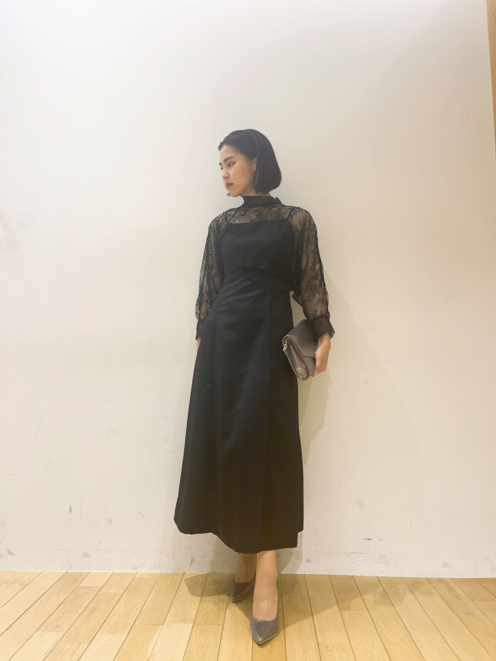 ブラック系のドレス、シルバー系のハンドバッグ、シルバー系のパンプスを着用したレディースの夏コーディネートの3枚目の写真