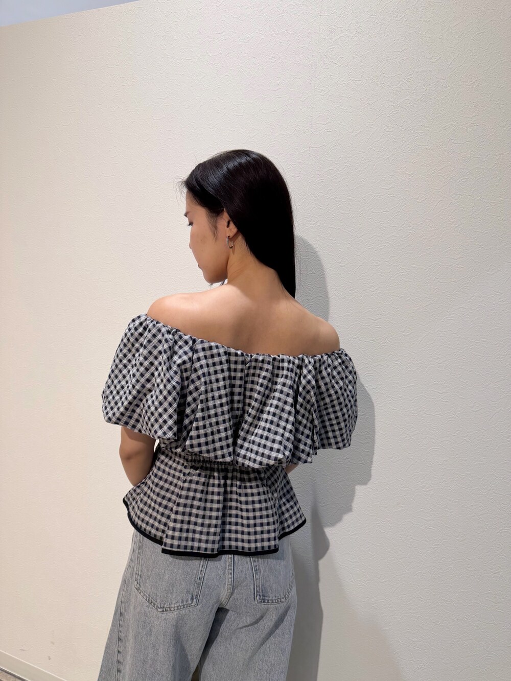 ブルー系のデニムパンツ、ホワイト系のサンダル、ホワイト系のハンドバッグを着用したレディースの夏コーディネートの6枚目の写真