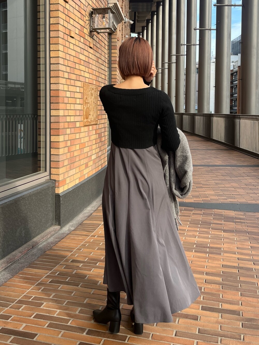 ホワイト系のノーカラーコート、ブラック系のワンピース、グレー系のショルダーバッグを着用したレディースの冬コーディネートの7枚目の写真