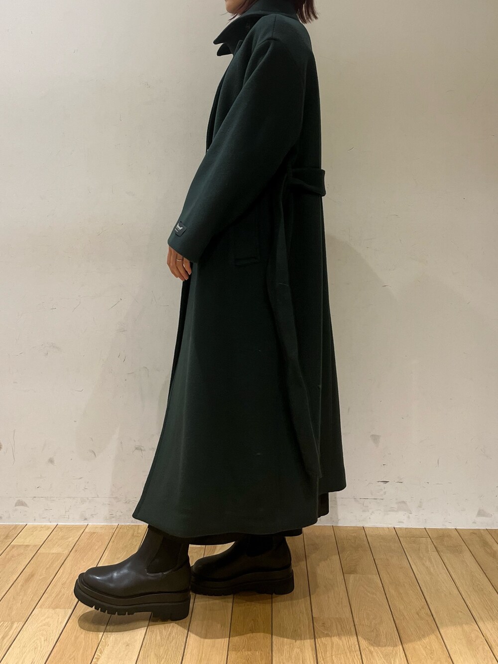 ブラック系のブーツ、グリーン系のニット/セーター、グリーン系のステンカラーコートを着用したレディースの冬コーディネートの5枚目の写真