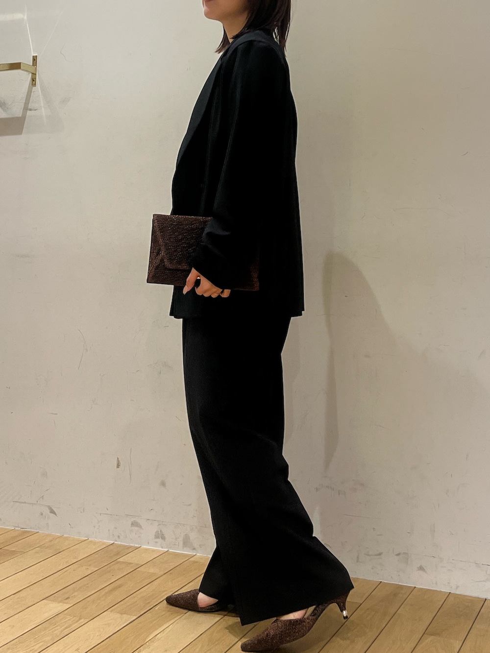 ホワイト系のTシャツ/カットソー、その他のクラッチバッグ、その他のパンプスを着用したレディースの冬コーディネートの2枚目の写真