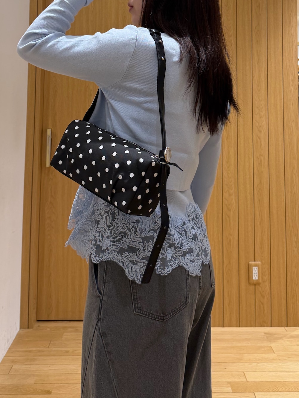 グレー系のデニムパンツ、ブルー系のニット/セーター、ブラック系のブーツを着用したレディースの秋コーディネートの5枚目の写真