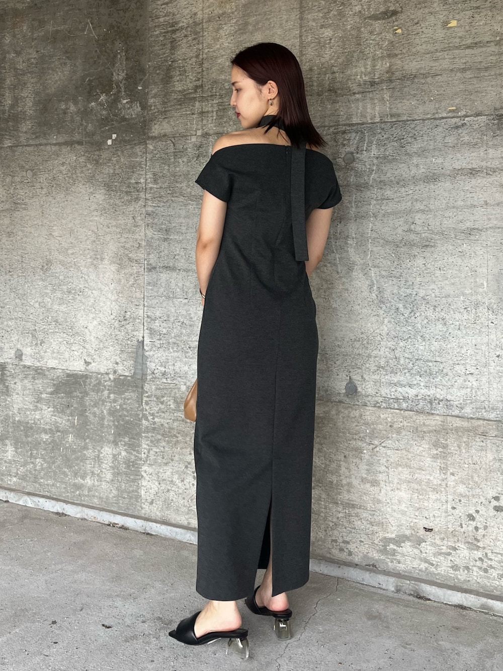 グレー系のワンピース、ブラウン系のハンドバッグ、ブラック系のサンダルを着用したレディースの夏コーディネートの3枚目の写真