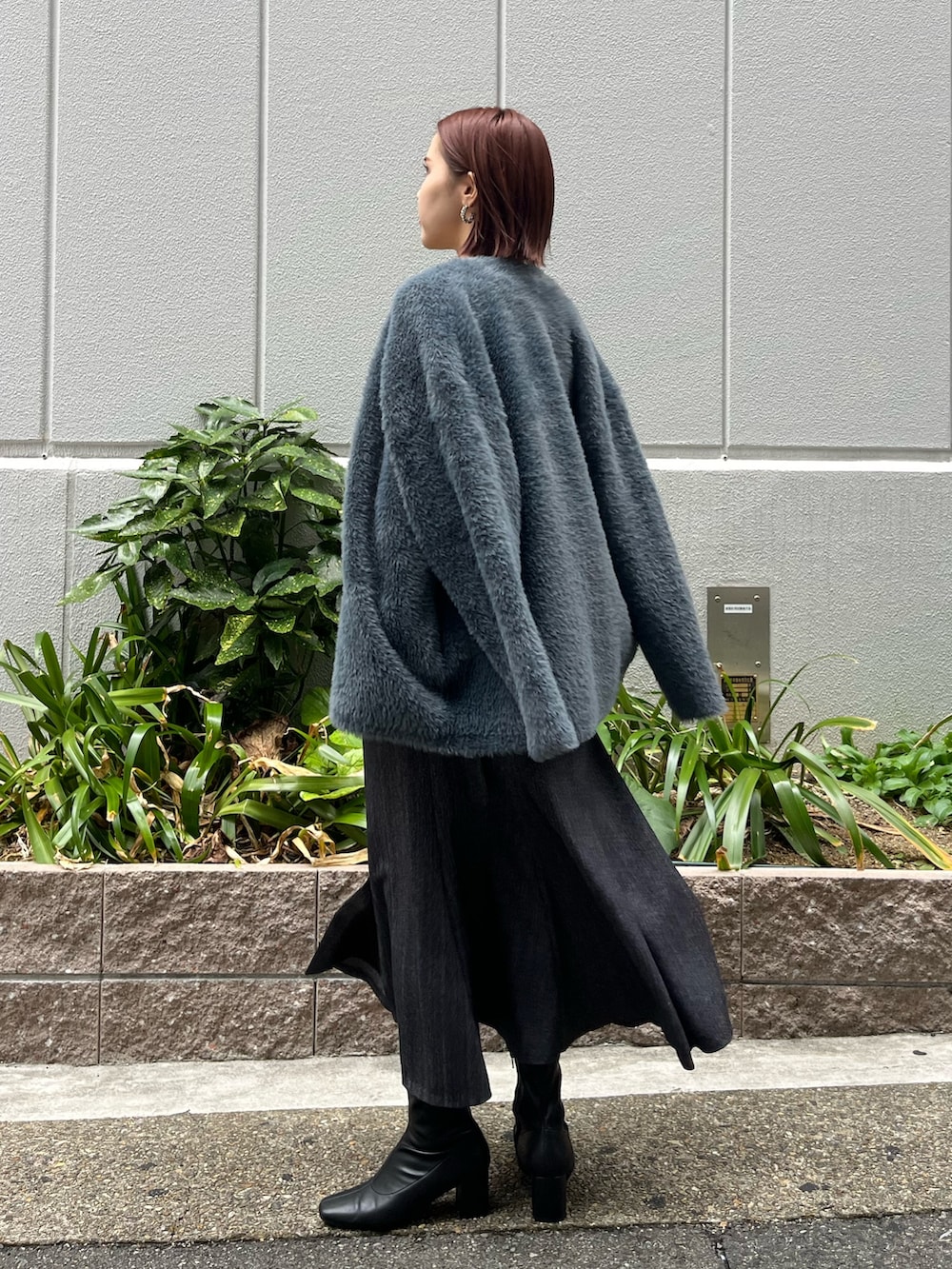 ブラック系のニット/セーター、グレー系のカーディガン/ボレロ、グレー系のスカートを着用したレディースの秋コーディネートの3枚目の写真