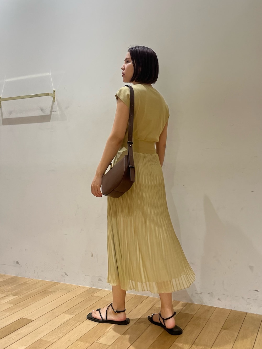 ブラック系のサンダル、グリーン系のワンピース、ブラウン系のショルダーバッグを着用したレディースの夏コーディネートの3枚目の写真