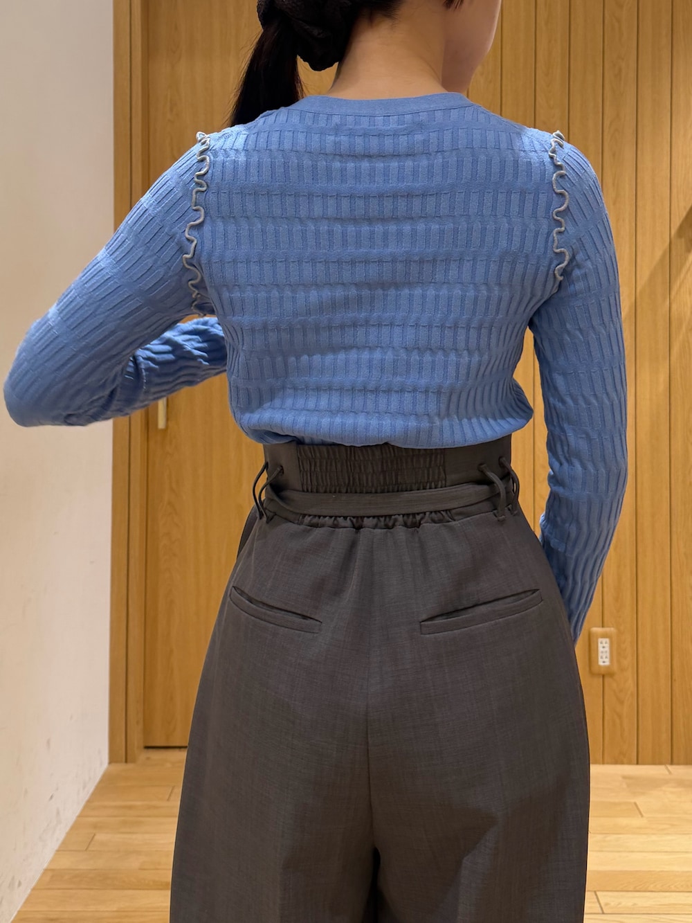 グレー系のその他パンツ、ブルー系のニット/セーター、ブラック系のサンダルを着用したレディースの春コーディネートの6枚目の写真