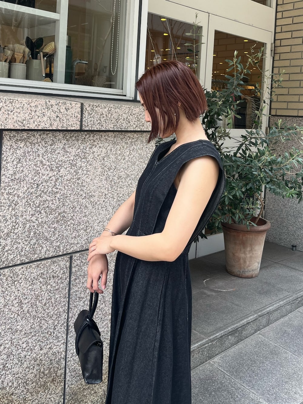 ブラック系のワンピース、その他のサンダル、ブラック系のハンドバッグを着用したレディースの春コーディネートの6枚目の写真