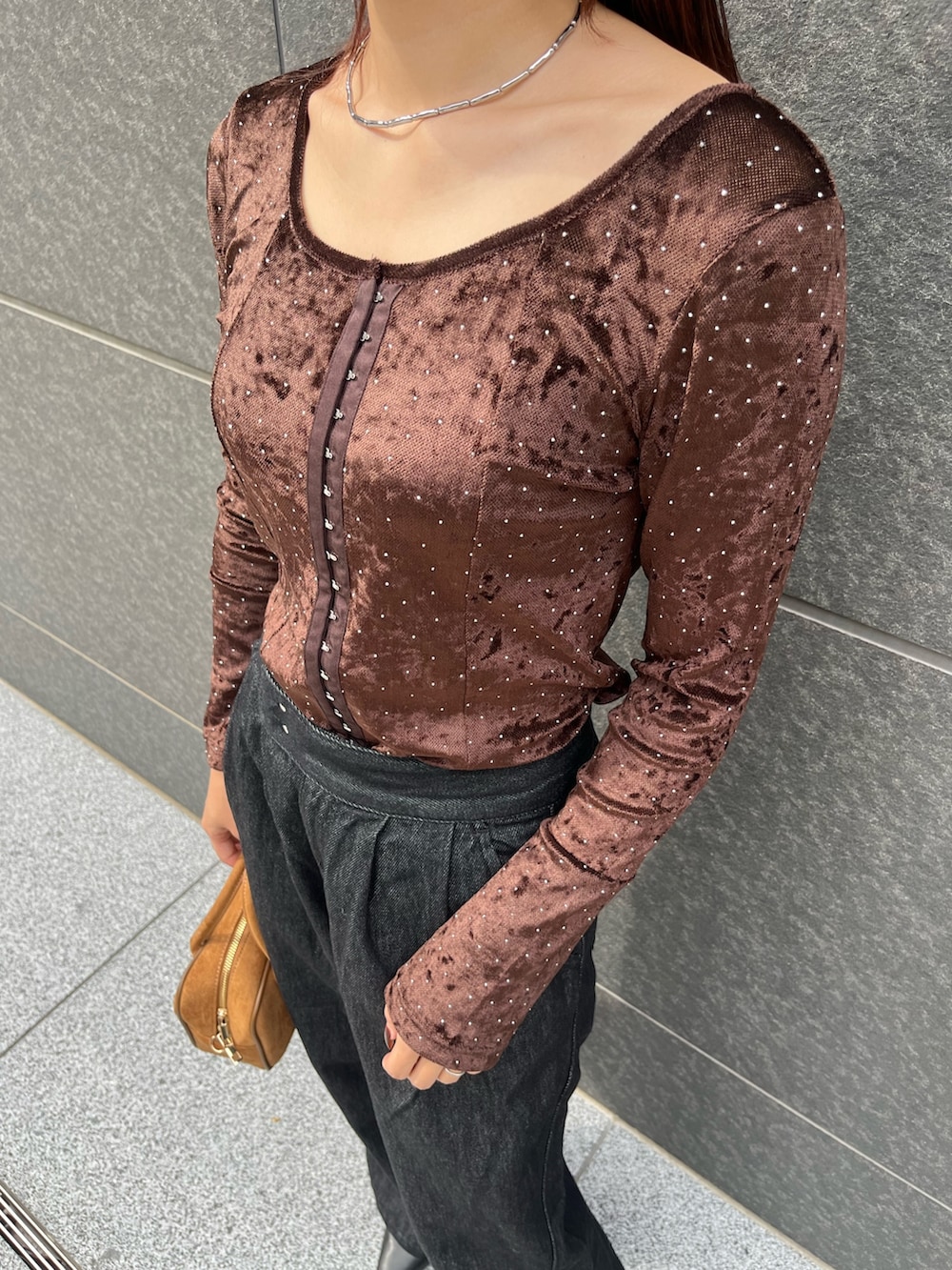 ブラック系のデニムパンツ、ブラウン系のハンドバッグ、ブラウン系のTシャツ/カットソーを着用したレディースの秋コーディネートの7枚目の写真