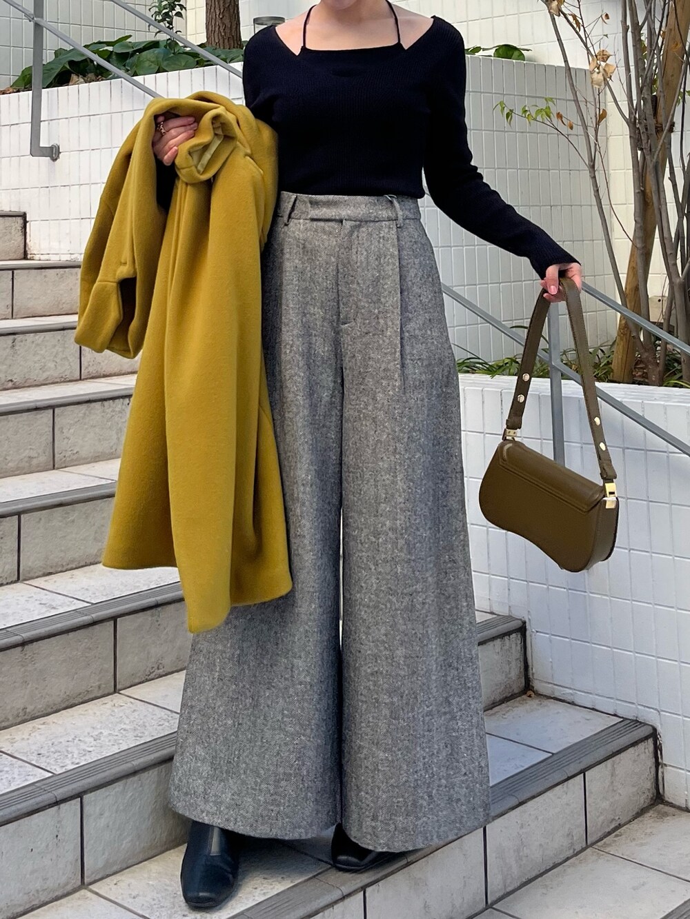 グリーン系のチェスターコート、ブラック系のその他パンツ、ブラック系のニット/セーターを着用したレディースの冬コーディネートの4枚目の写真