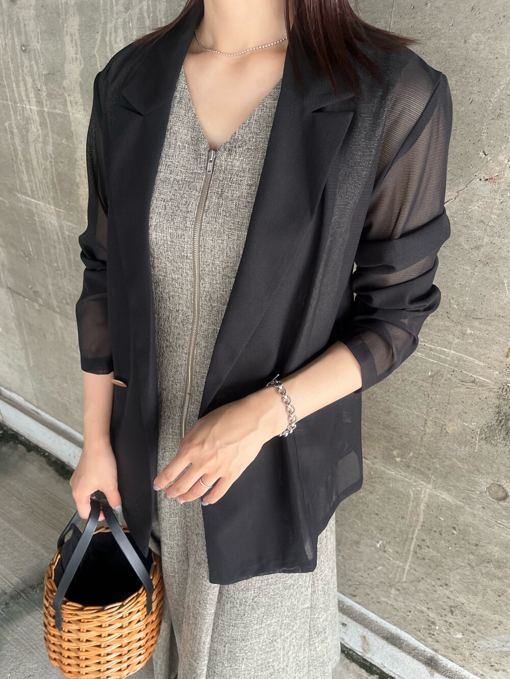 ブラック系のテーラードジャケット、ブラウン系のワンピース、ブラウン系のハンドバッグを着用したレディースの夏コーディネートの6枚目の写真