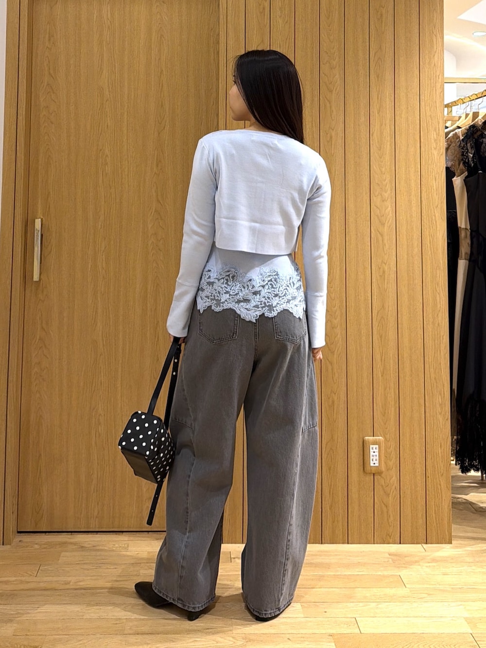 グレー系のデニムパンツ、ブルー系のニット/セーター、ブラック系のブーツを着用したレディースの秋コーディネートの3枚目の写真