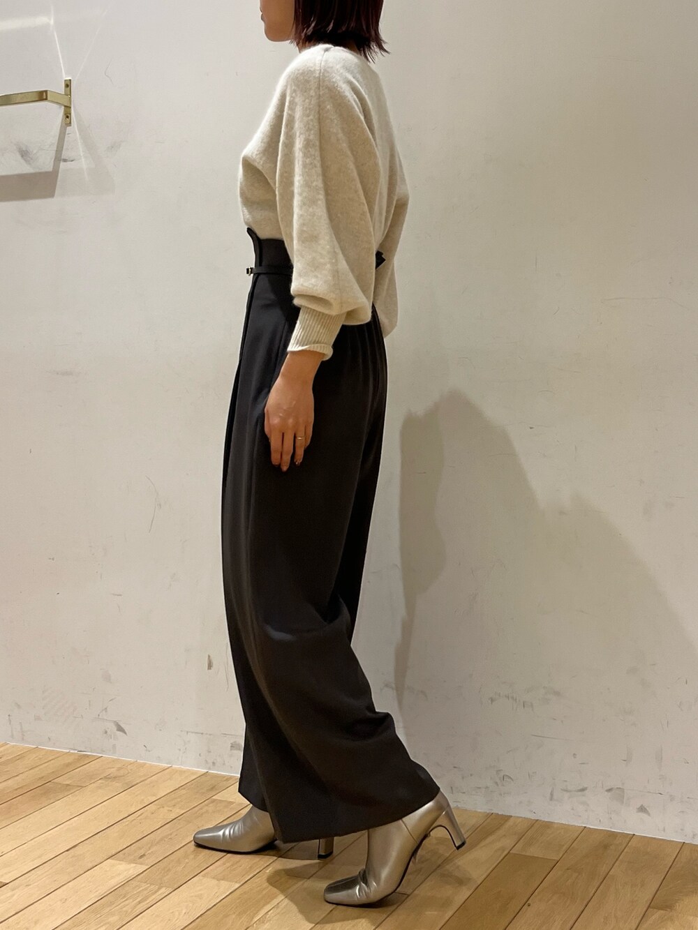 グレー系のその他パンツ、ホワイト系のニット/セーター、シルバー系のブーツを着用したレディースの秋コーディネートの2枚目の写真