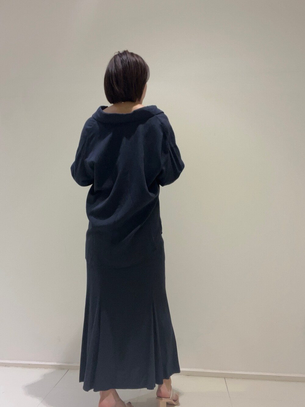 ホワイト系のニット/セーター、ブルー系のスカート、ブルー系のシャツ/ブラウスを着用したレディースの春コーディネートの4枚目の写真