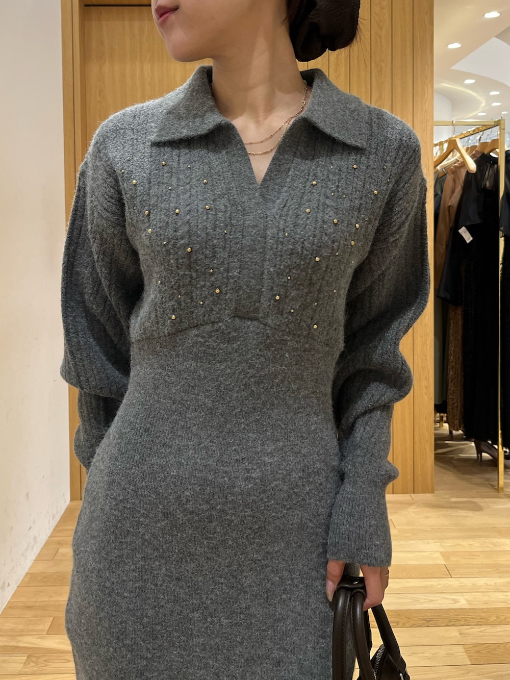 グレー系のワンピース、ホワイト系のダウンジャケット/コート、ブラウン系のボストンバッグを着用したレディースの秋コーディネートの9枚目の写真