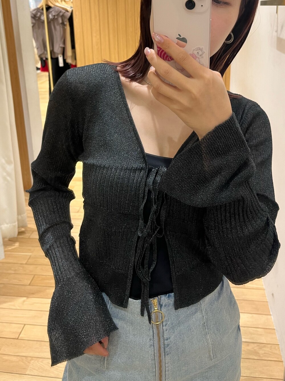 ブルー系のデニムパンツ、ブラック系のスニーカー、ブラック系のカーディガン/ボレロを着用したレディースの春コーディネートの5枚目の写真