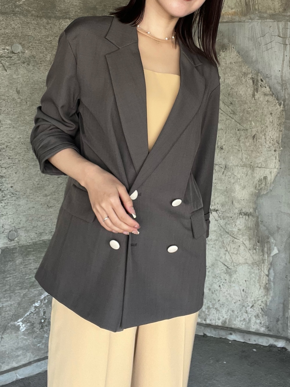 イエロー系のパンツドレス、ベージュ系のパンプス、ベージュ系のショルダーバッグを着用したレディースの春コーディネートの5枚目の写真