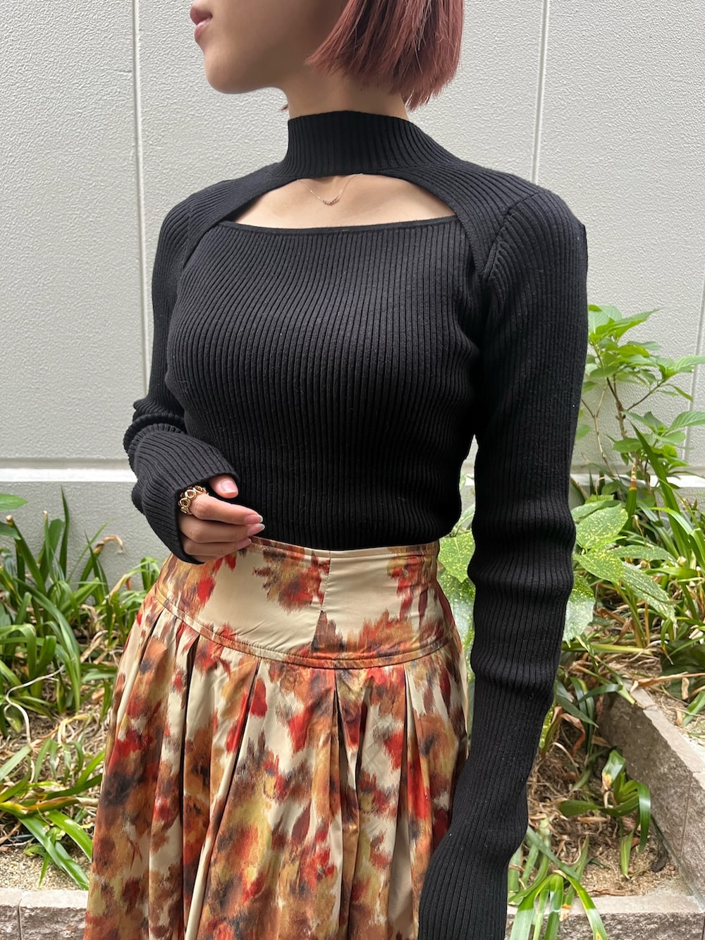 オレンジ系のスカート、ブラック系のニット/セーター、ベージュ系のムートンコートを着用したレディースの秋コーディネートの4枚目の写真