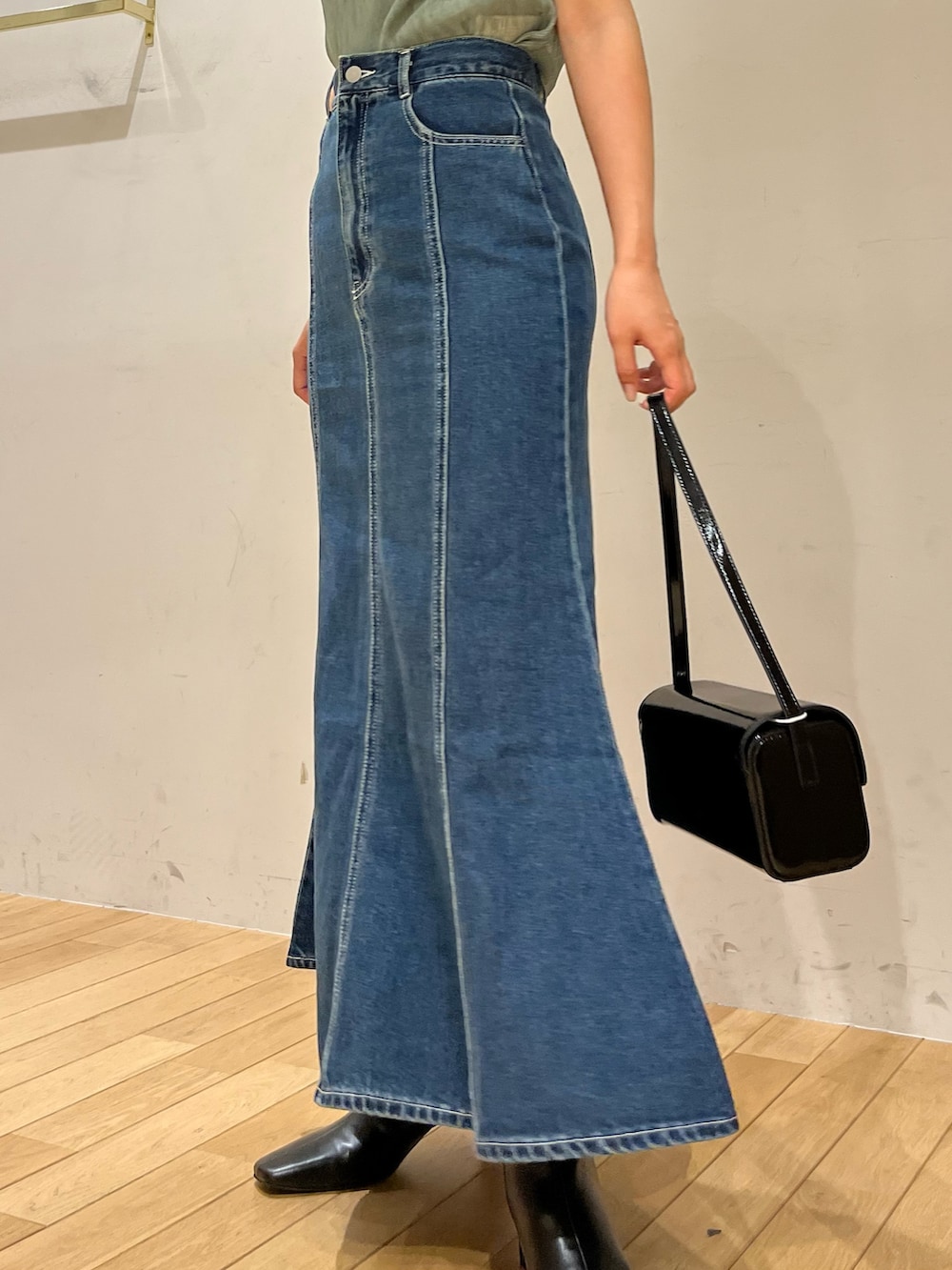 ブルー系のデニムスカート、グリーン系のシャツ/ブラウス、ブラック系のブーツを着用したレディースの夏コーディネートの5枚目の写真