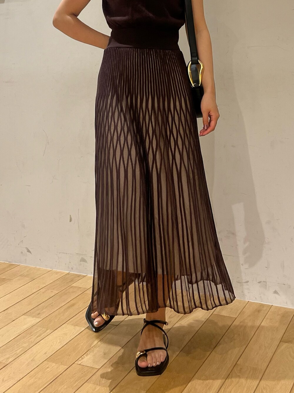 ブラック系のサンダル、ブラウン系のワンピース、ブラック系のショルダーバッグを着用したレディースの夏コーディネートの5枚目の写真