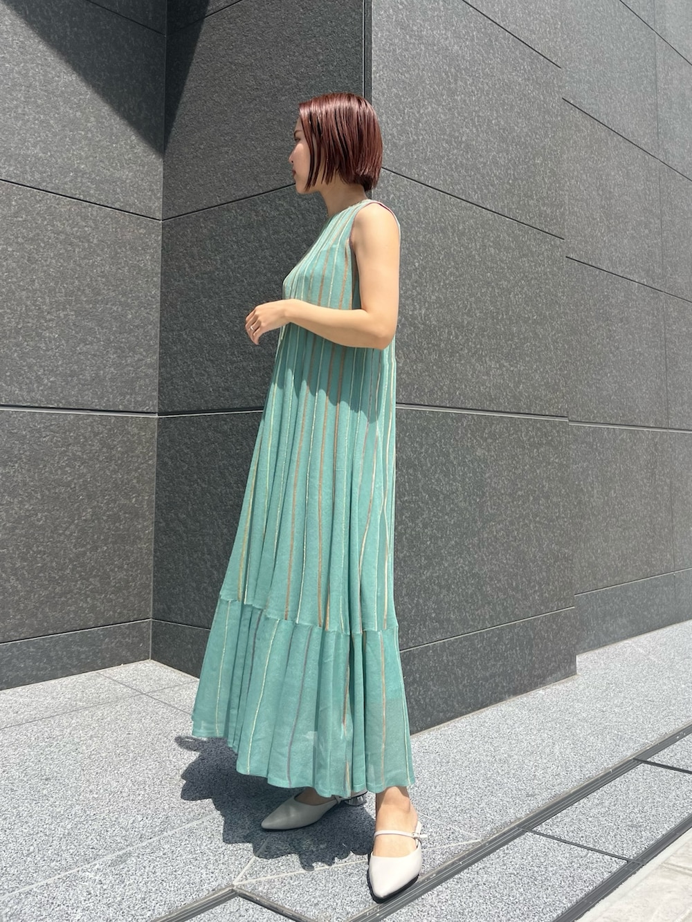 グリーン系のワンピース、ホワイト系のベルトを着用したレディースの春コーディネートの3枚目の写真