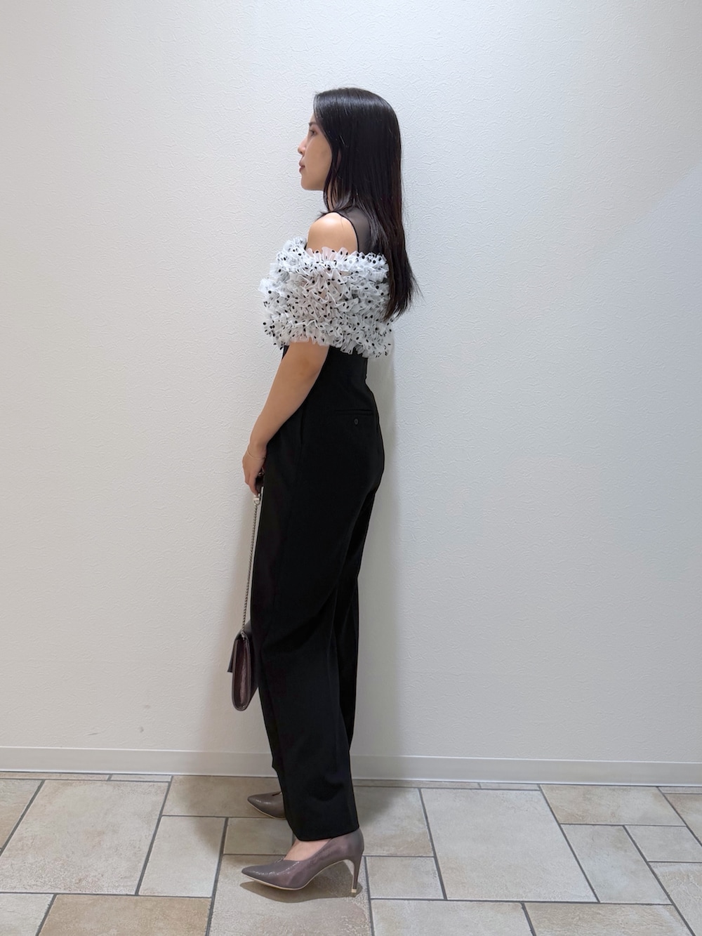 その他のパンツドレス、シルバー系のクラッチバッグ、シルバー系のパンプスを着用したレディースの秋コーディネートの2枚目の写真