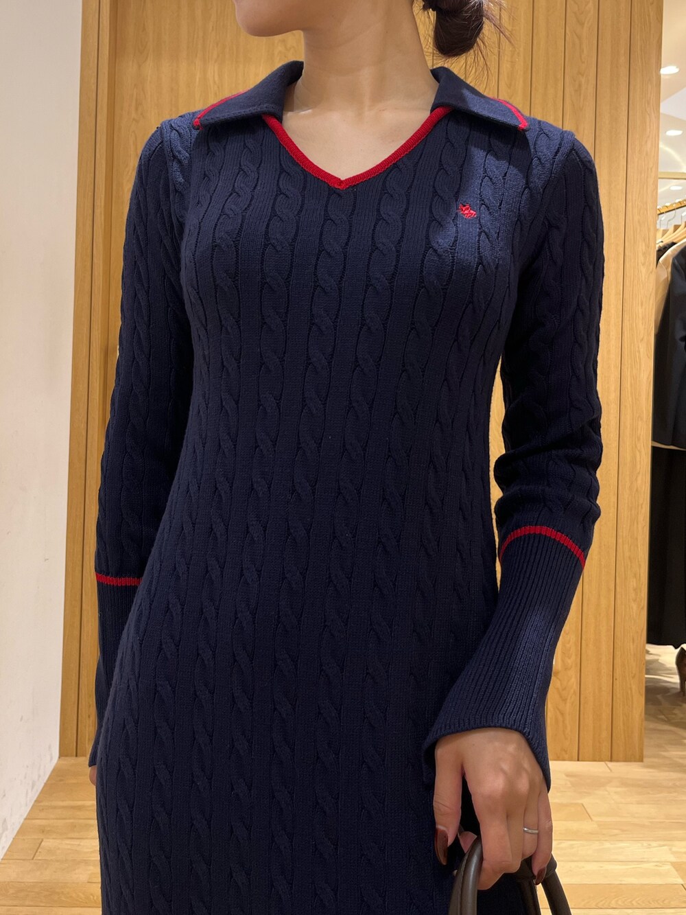 ブルー系のワンピース、ブラウン系のボストンバッグ、ブラウン系のパンプスを着用したレディースの秋コーディネートの4枚目の写真