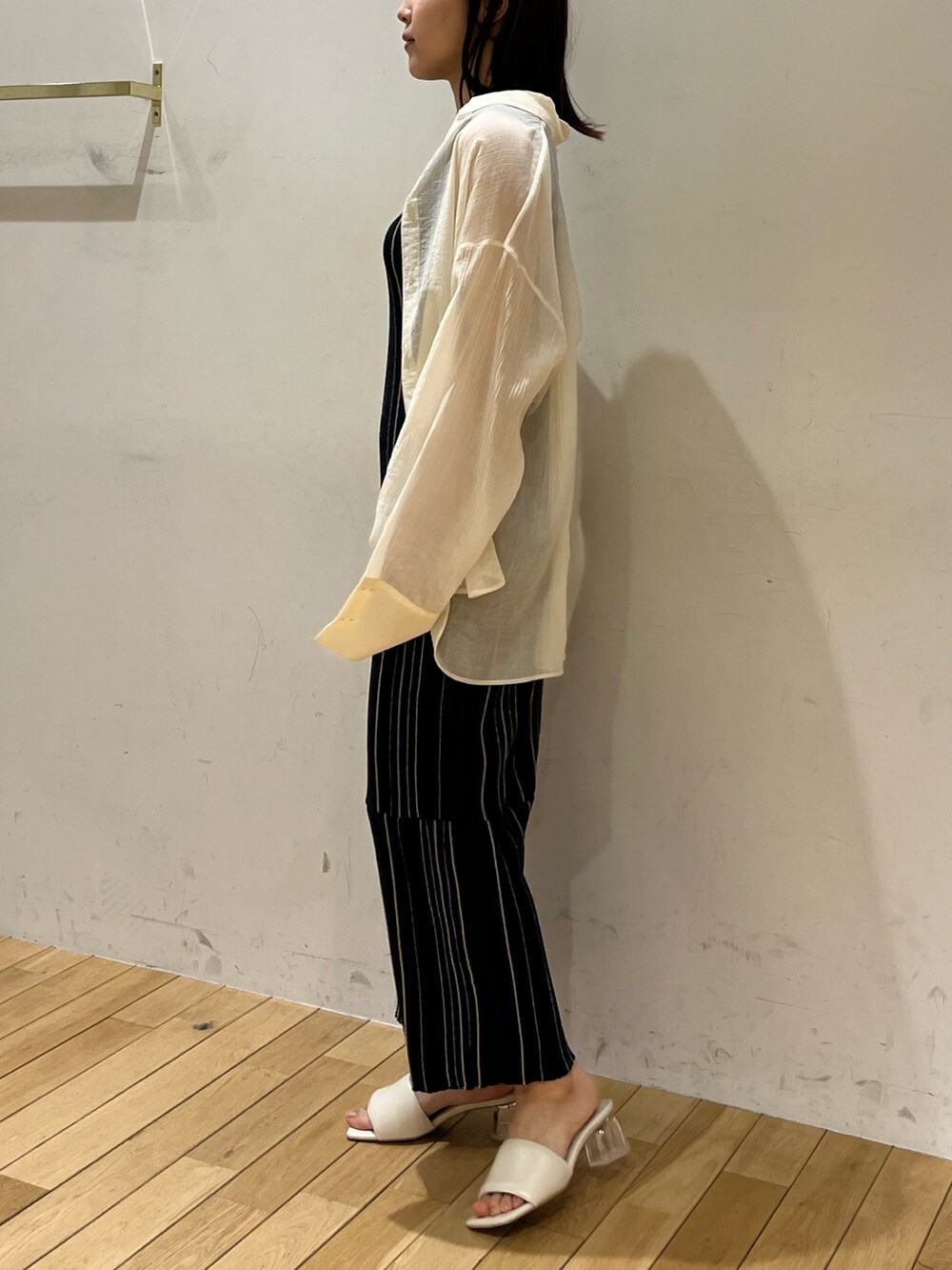 ブルー系のワンピース、ホワイト系のシャツ/ブラウス、ホワイト系のサンダルを着用したレディースの春コーディネートの2枚目の写真